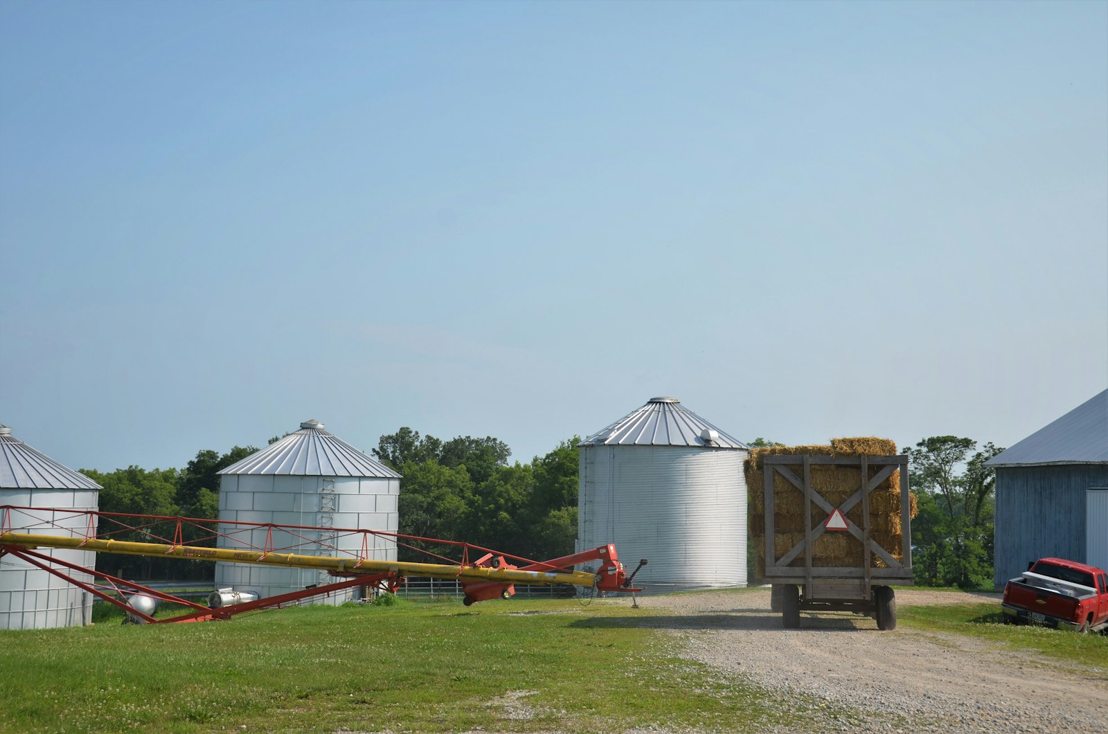 white and red metal shed on green grass field during daytime